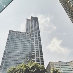Low angle view of modern building against cloudy sky