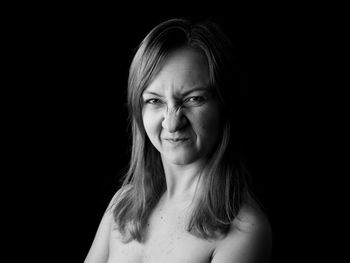 Portrait of woman against black background