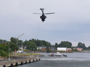 Airplane flying over river against sky