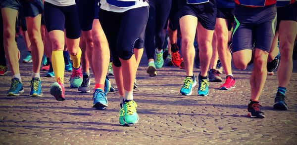 Low section of athletes running marathon on road