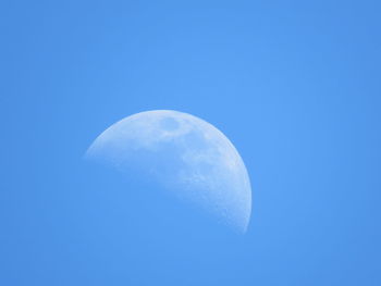 Low angle view of moon against clear blue sky