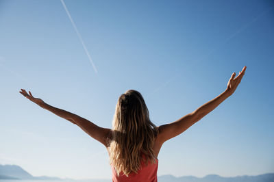 Rear view of woman standing against sky