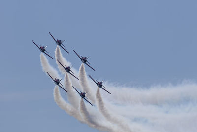 Low angle view of airshow against sky