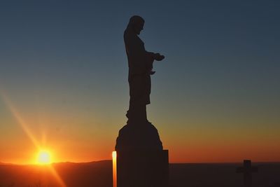 Silhouette statue against sky during sunset