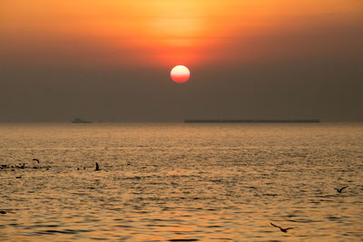 Scenic view of sea against orange sky