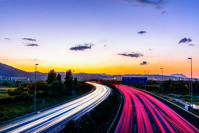 High angle view of light trails on highway at sunset