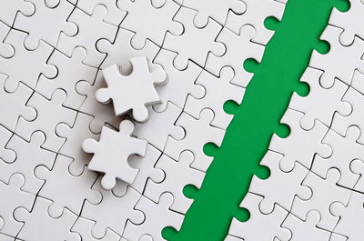 High angle view of jigsaw puzzle against green background
