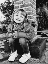 Portrait of smiling girl sitting outdoors