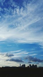 Silhouette buildings against cloudy sky