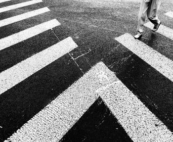 Low section of woman walking on zebra crossing