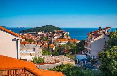 Buildings in town against clear blue sky