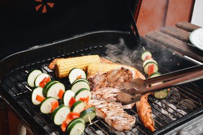 High angle view of vegetables and meat on barbecue grill