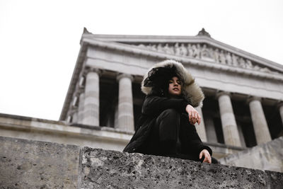 Low angle view of woman standing against building