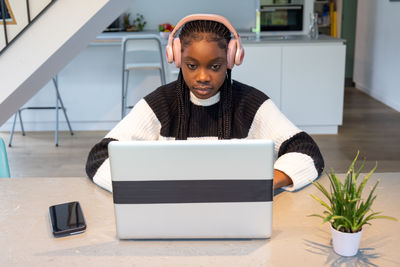 Portrait of young man using laptop while sitting on table