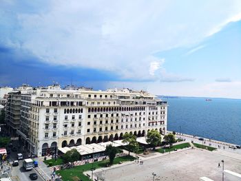 High angle view of buildings by sea against sky