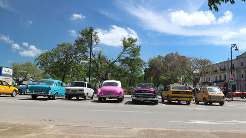 Cars on street in city against sky