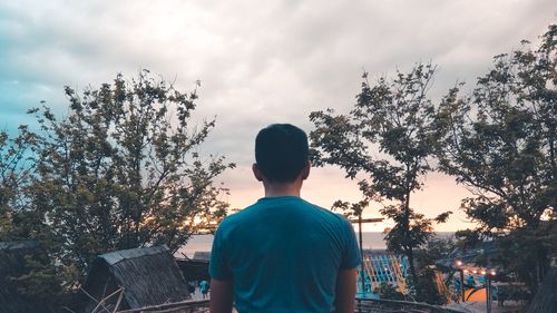 Rear view of man against sky and trees