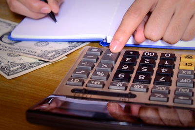 Close-up of woman using smart phone on table