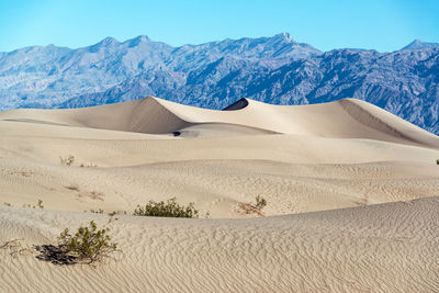 Scenic view of desert against clear blue sky