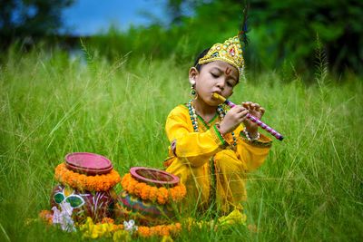 Boy holding flowers on field