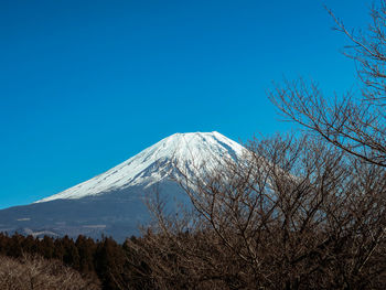 Scenic view of snowcapped mountains against clear blue sky