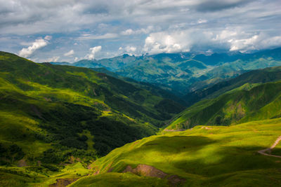 Scenic view of valley and mountains against sky