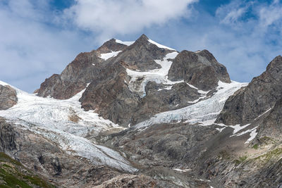 Low angle view of snowcapped mountains against sky