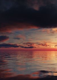 Scenic view of sea against dramatic sky during sunset