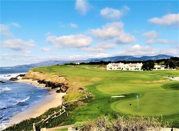 Scenic view of landscape by sea against sky