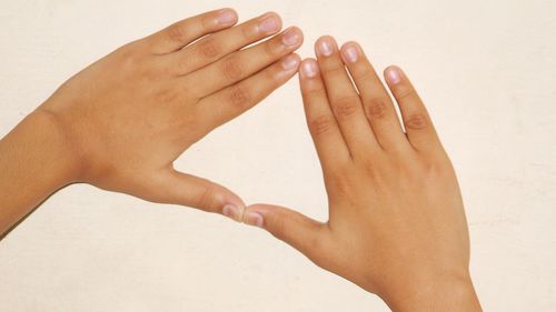 Close-up of hands gesturing against white background