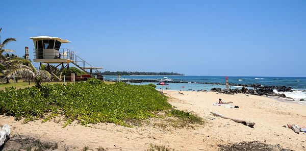 Lifeguard hut at beach in hawaiian paradise park against clear sky