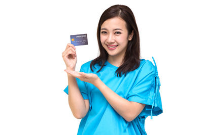 Portrait of smiling young woman using phone against white background