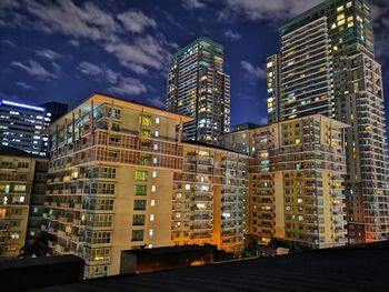 Illuminated buildings against sky at night