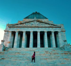 Young woman standing on steps against building