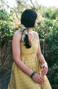 Young woman standing by plants