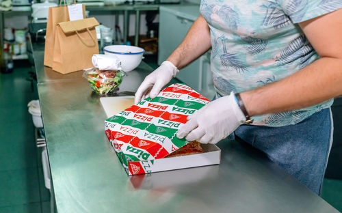 Unrecognizable cook preparing pizza to takeaway