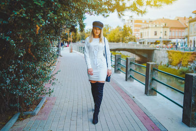 Portrait of beautiful young woman walking on footbridge