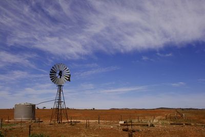 Traditional windmill on field against sky