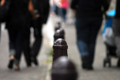 Low section of people walking on street in city