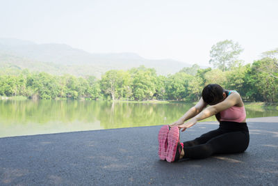 Woman exercising by lake