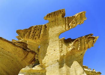 Low angle view of statue against blue sky