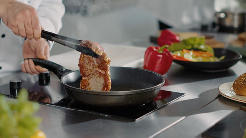 Midsection of chef preparing food at kitchen