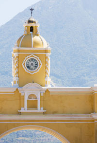 Low angle view of clock tower amidst buildings against sky