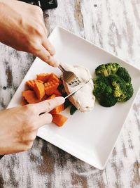 Midsection of person eating food on table