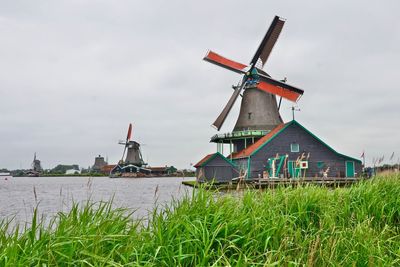 Traditional windmill on field against sky