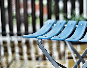 Cropped image of blue plastic chair in back yard