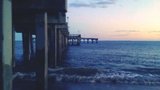 sea, water, built structure, sky, architecture, horizon over water, sunset, cloud - sky, waterfront, scenics, building exterior, tranquility, nature, tranquil scene, beauty in nature, pier, cloud, beach, dusk, outdoors