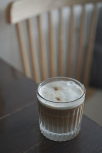 There is a freshly made latte on the wooden table