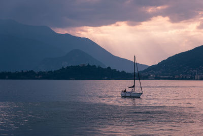 Sailboat in sea against mountains