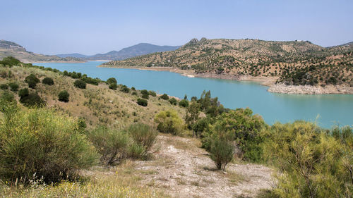 Scenic view of lake and mountains against clear sky